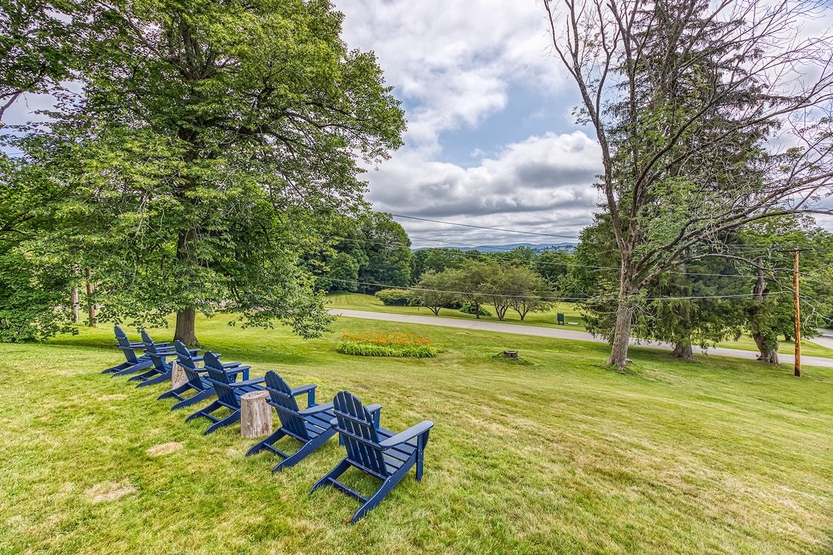 Adirondack chairs outside the fire pit looking out on the view down the hill